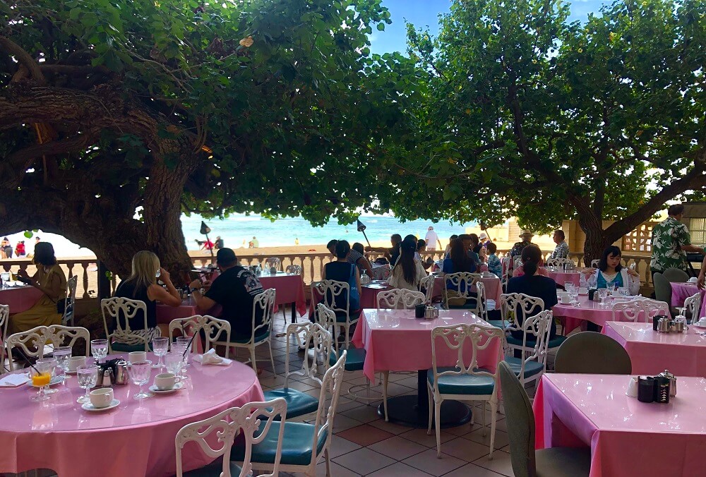 Hau Tree Restaurant is a casual beachfront dining experience located at the Kaimana Beach Hotel in Honolulu, offering a menu featuring delicious brunch, lunch, and dinner options with a beautiful ocean view.